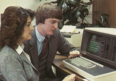 RJ Young salesman and woman working on a computer in the 70s.